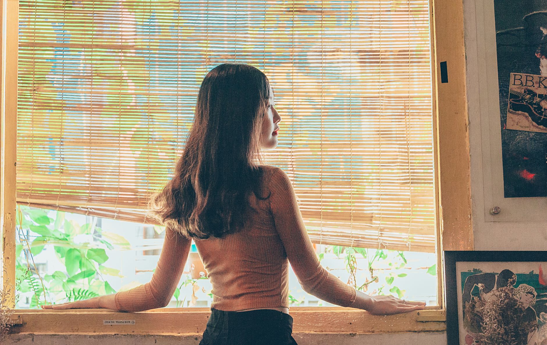 窓辺で考える女性の後ろ姿