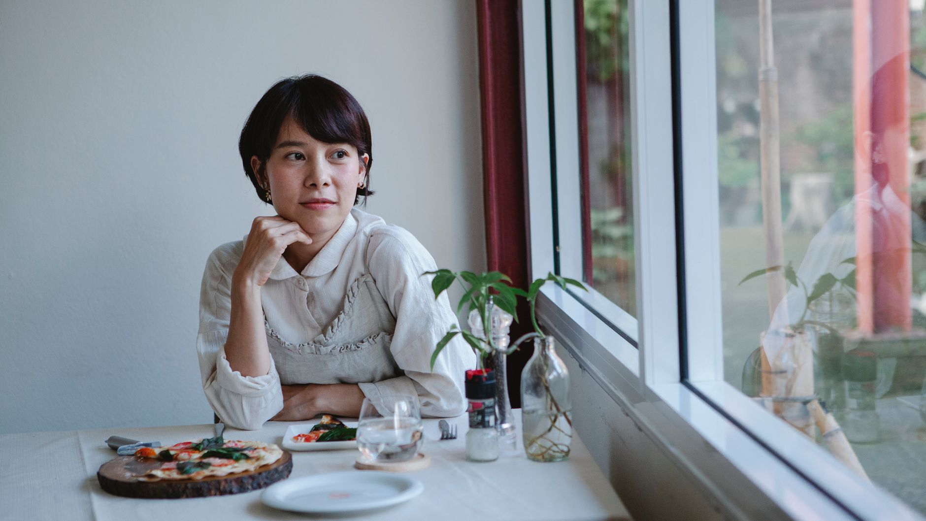 カフェの窓辺で物思う女性